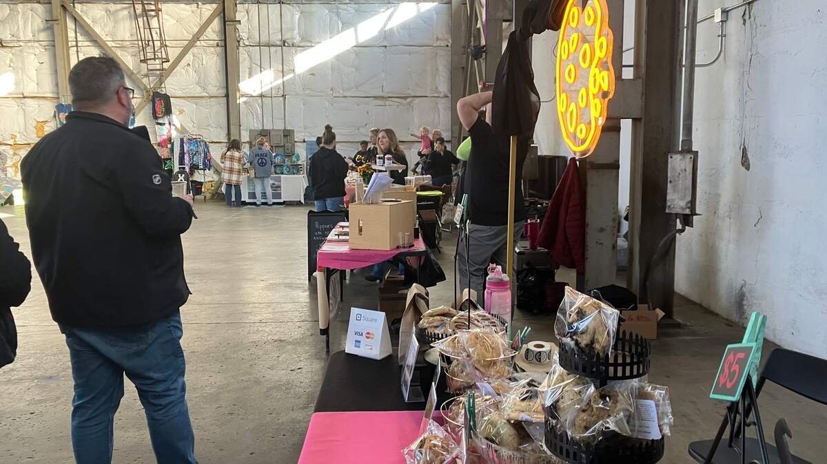 Vendors talk with attendees at the Night Market at Penguin City Brewing Company.