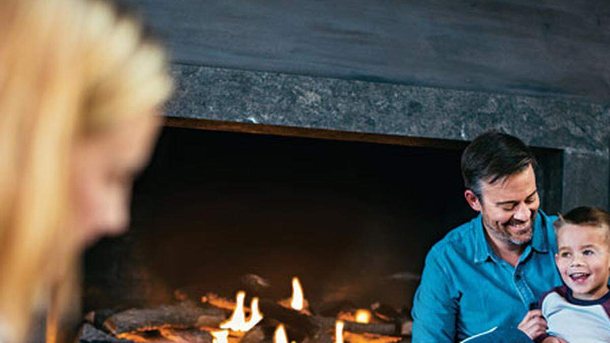 A family relaxes in front of the fireplace.