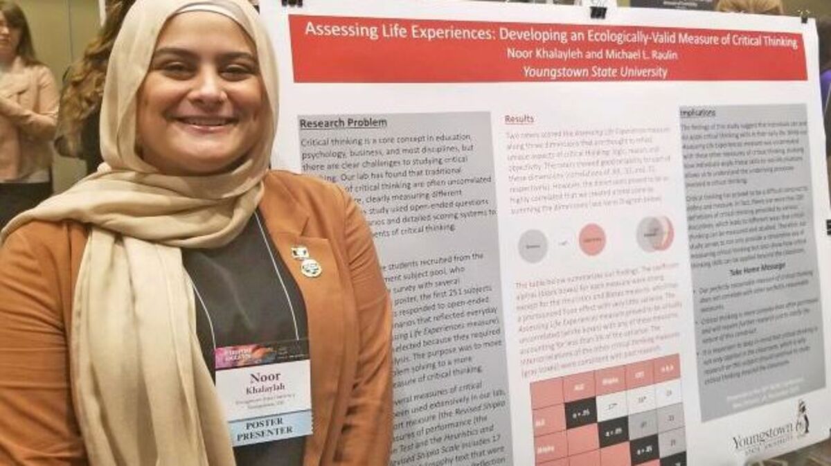 Youngstown State University student Noor Khaleyleh stand next to her winning poster depicting her research project at the National Collegiate Honors Council Conference in New Orleans. (Photo courtesy of YSU)