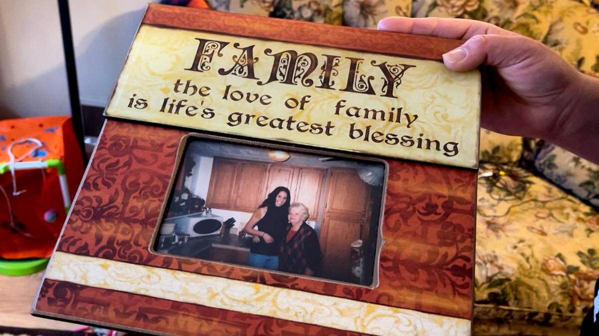 Denise Raub of Poland holds a photo of her and her grandmother, who died of COVID-19 in January 2021. In coping with her grief, Raub relapsed after seven years of sobriety.
