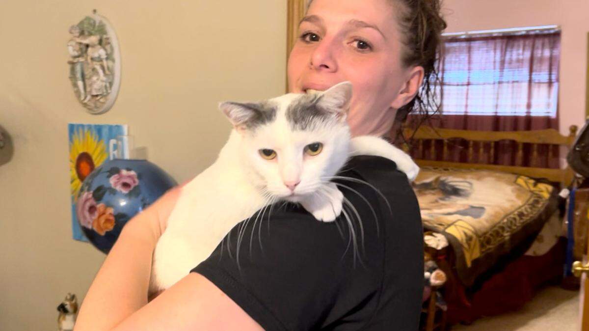 Denise Raub, 32, holds her cat at her Poland home on March 31, 2022.