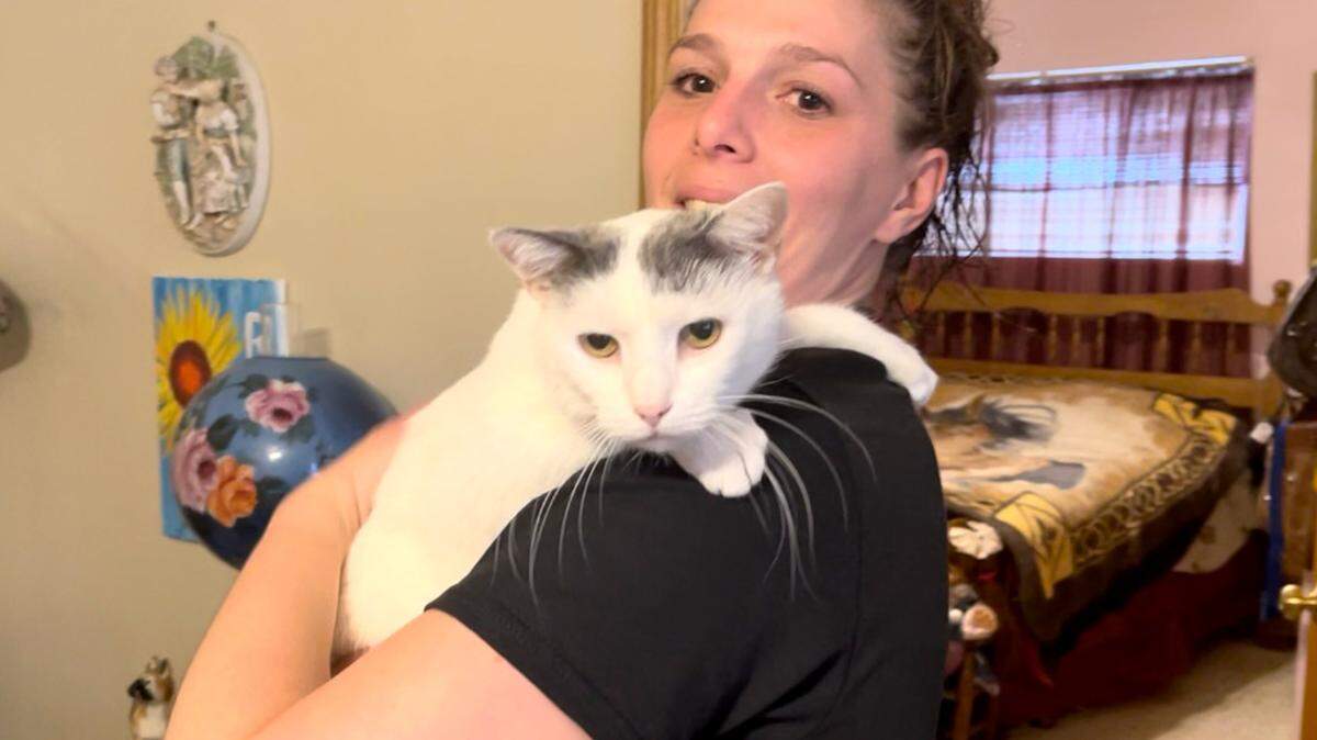 Denise Raub, 32, holds her cat at her Poland home on March 31, 2022.