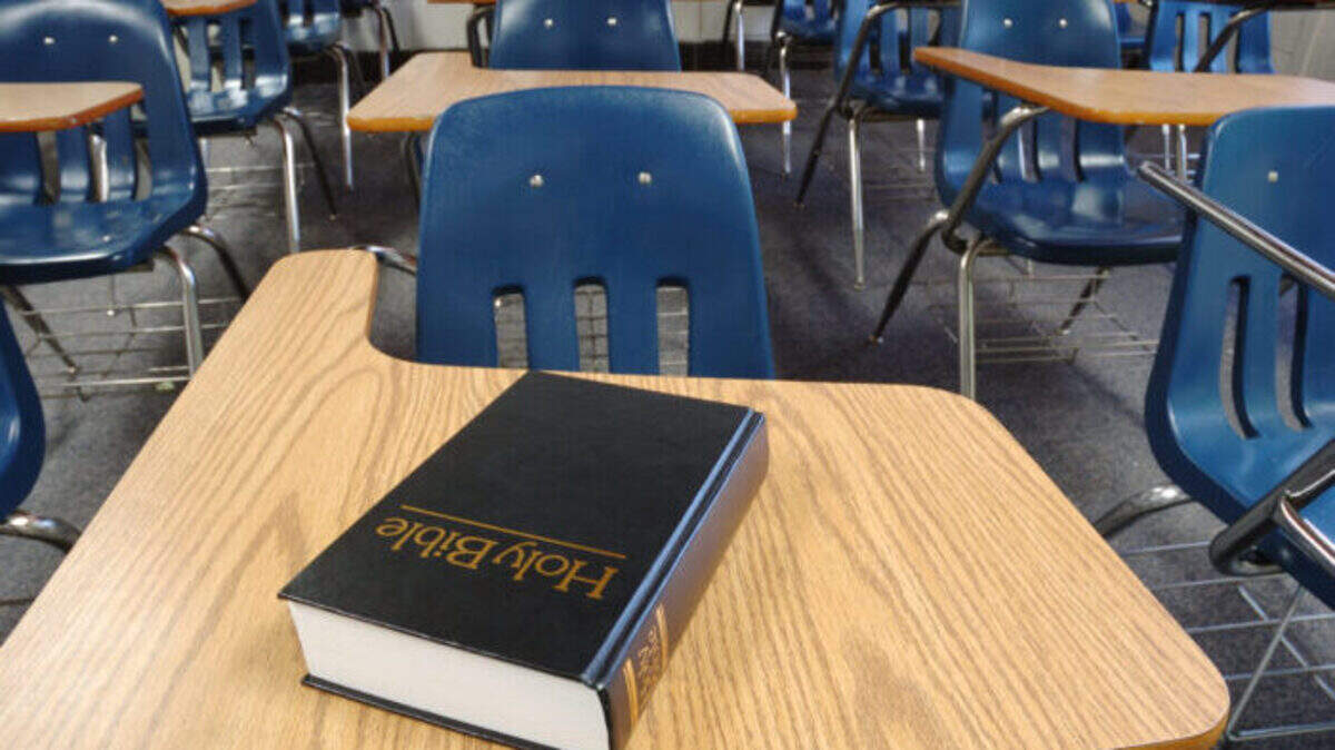 Bible on a school desk in a classroom.