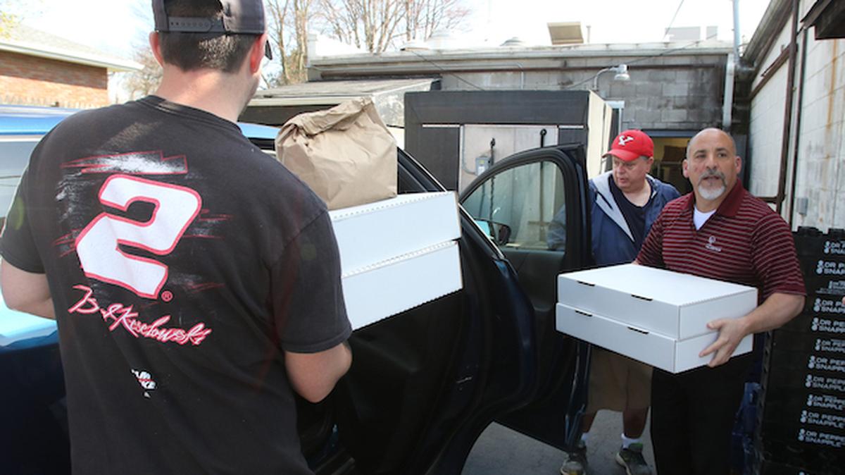 Belleria Pizza and the United Way of Youngstown and the Mahoning Valley combined to feed Struthers and Youngstown firefighters and first responders with pizza, cavatelli and antipasto salad. Bob Sass, in the foreground, a cook for the Struthers Belleria, and Frank Lellio and Bob Camardo, owners, load the food that was to be delivered  by volunteers. (Bob Yosay/Mahoning Matters)