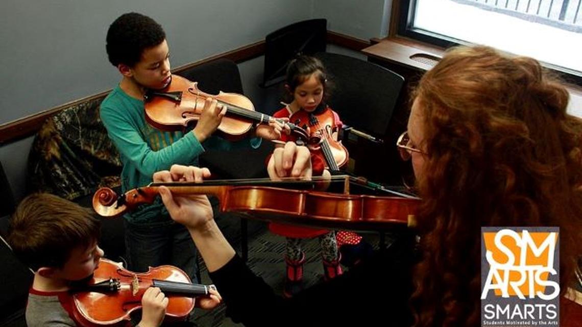 Students play violins in a Students Motivated by the Arts program at Ohio One in downtown Youngstown. (Photo by Lindsay Cameron Photography)