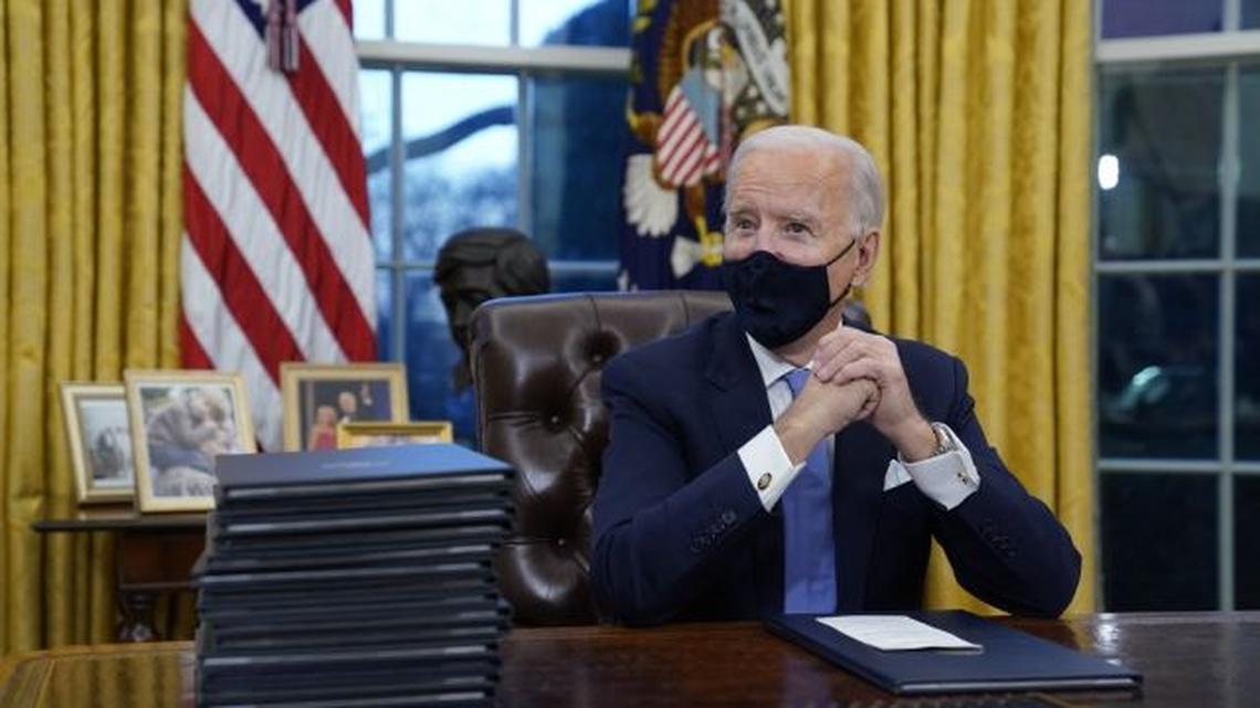 President Joe Biden waits to sign his first executive order in the Oval Office of the White House today. (AP Photo | Evan Vucci)