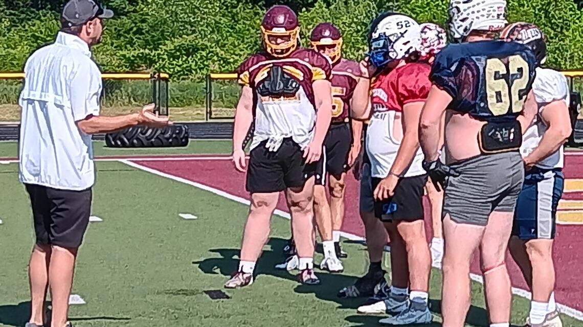 South Range head football coach Dave Rach, left, who is serving as the Ohio head coach for this year’s 45th annual Ohio-Pennyslyvania Stateline Football Classic, makes a point to the Buckeyes’ linemen during a practice session Thursday evening at South Range High School.