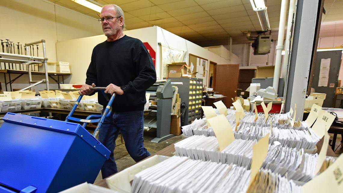 Board of Elections worker Bob Moody moves boxes of ballots at the Trumbull County Board of Elections in Warren on Nov. 3, 2020.