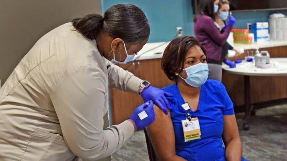Venice Williams, right, a nurse manager at Wake Forest Baptist Medical Center, receives the COVID-19 vaccine at the medical center Dec. 15, 2020. (Walt Unks | AP)