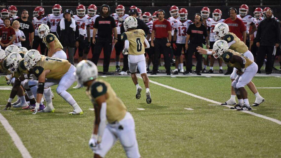 Youngstown Ursuline quarterback Jack Ericson (far right) prepares to take a shotgun snap as teammate D.C. Ferrell (0) goes in motion during Thursday night’s season-opening football game against Steubenville at Youngstown State’s Stambaugh Stadium. Ursuline won the game, 36-28.