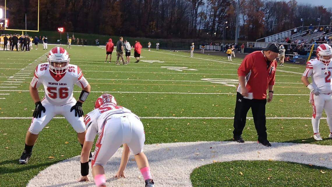 Beaver Local assistant coach Josh Ludwig, right, watches as players go through pregame drills before Friday night’s Division IV football playoff game at Streetsboro.