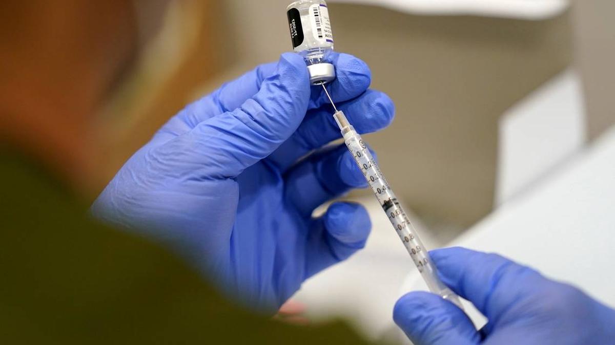 A healthcare worker fills a syringe with the Pfizer COVID-19 vaccine at Jackson Memorial Hospital in Miami. LYNNE SLADKY AP