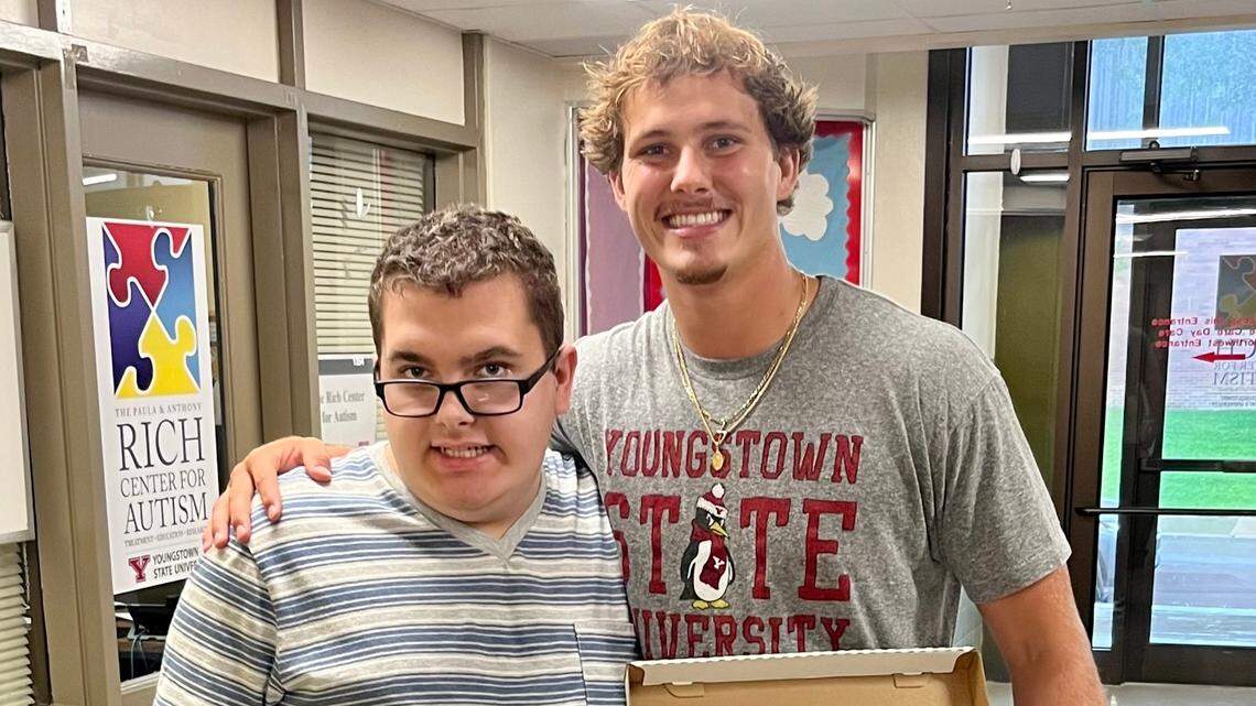 Mitch Davidson shows off his custom cleats with Rich Center high school 3 student Michael Fuller.