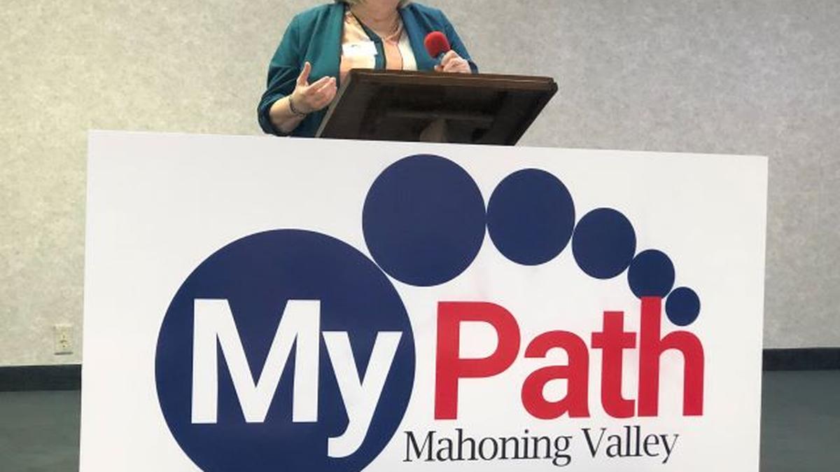 Gerri Jenkins, executive director of MyPath Mahoning Valley, unveils the organization's new name and logo at the Youngstown Event Center. (Contributed photo)
