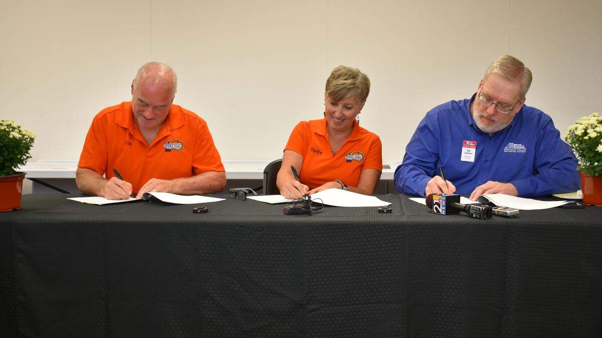 (Left to right) Jim Amey, Toni Amey and Bill Lawson, Mahoning Valley Historical Society executive director sign acquisition agreement to create an Idora Park Experience exhibit in Youngstown, Ohio. 