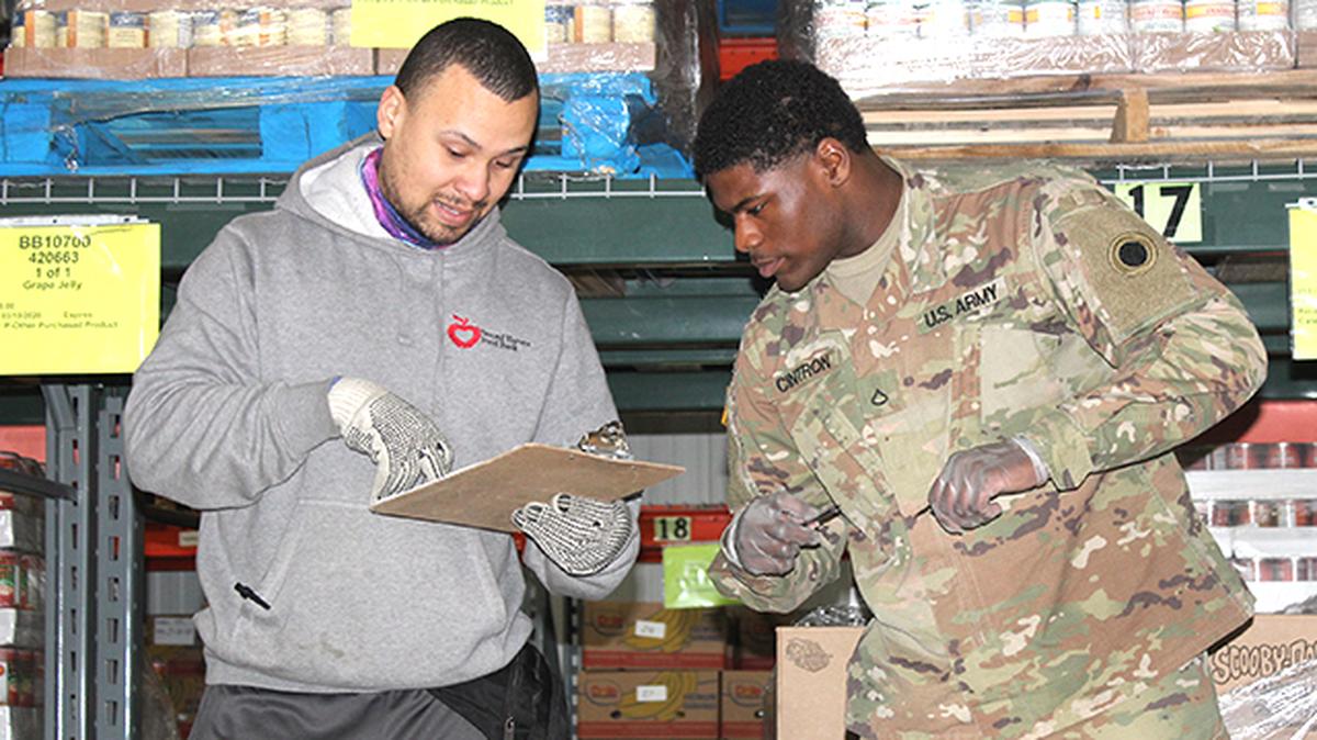 National Guard Pfc. Laron Cintron of Hubbard and Second Harvest Food Bank of the Mahoning Valley employee Jose Rosario of Puerto Rico help coordinate local food assistance response Monday at the Second Harvest facility in Youngstown. Responding to food assistance needs during the COVID-19 outbreak, 20 guardsmen and women from the region will be helping the food bank distribute food to the bank's more than 100 member agencies for the next month. (Photo by Justin Dennis | Mahoning Matters)