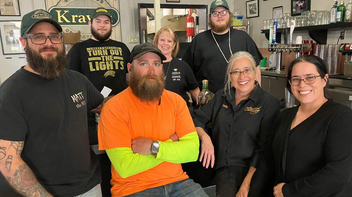 Kravitz Deli owner Matt Rydarowicz, left, poses with family and workers at the restaurant.