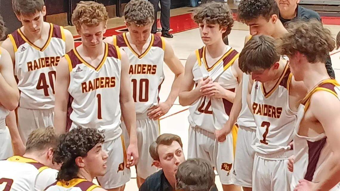 South Range head coach Pat Carden, lower middle, talks strategy with his team in a timeout during Tuesday night’s D3 district semifinal boys’ basketball game against Lake County Perry at Salem High School.