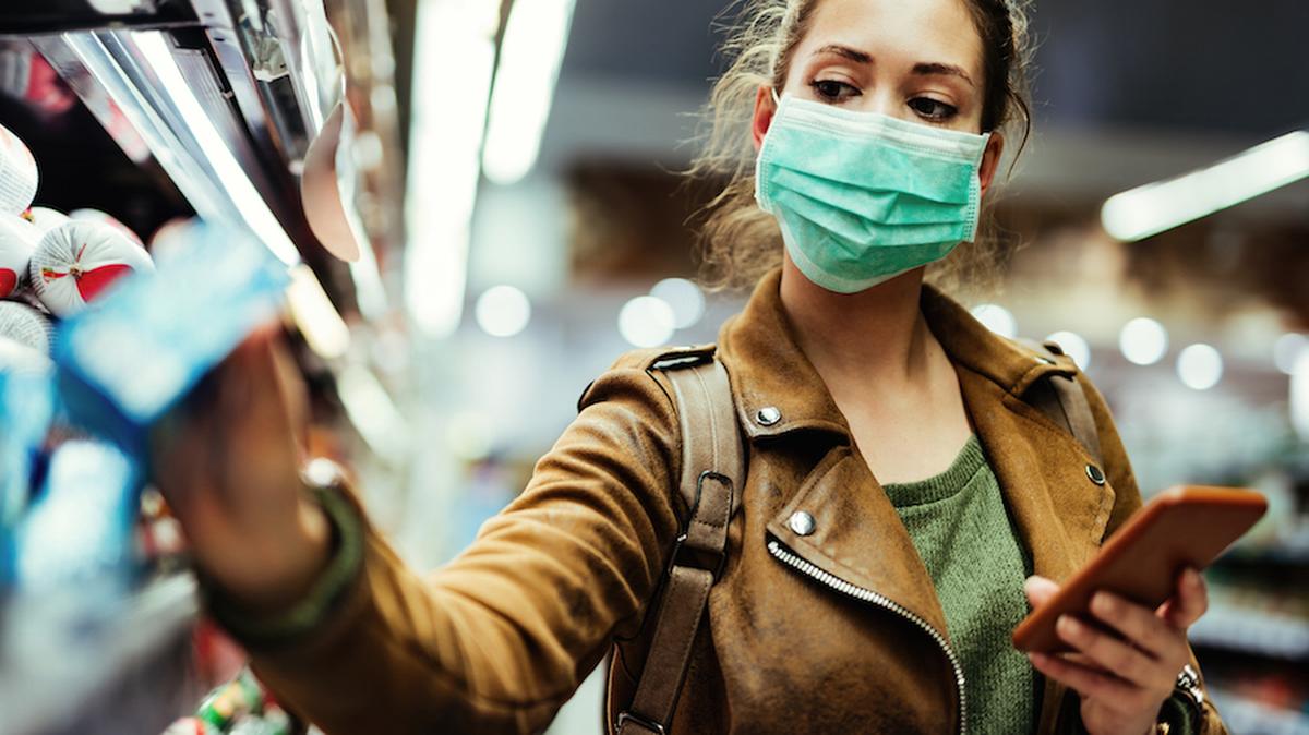 A woman wears a non-medical face mask while grocery shopping. Photo: iStock/Getty Images