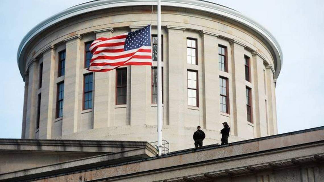 FILE - In this Jan. 13, 2021 file photo, fwo Ohio State Highway Patrol troopers look out from the Ohio Statehouse roof in Columbus.
