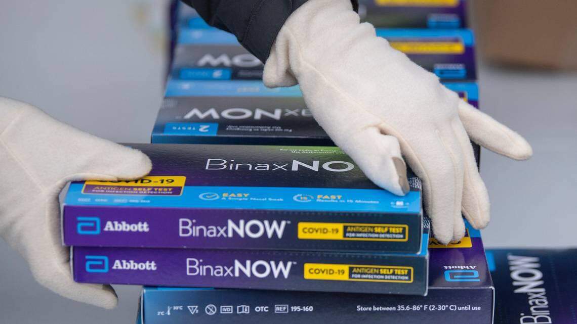 Youngstown City Health Department worker Faith Terreri grabs two at-home COVID-19 test kits to be handed out during a distribution in Youngstown on Dec. 30, 2021.