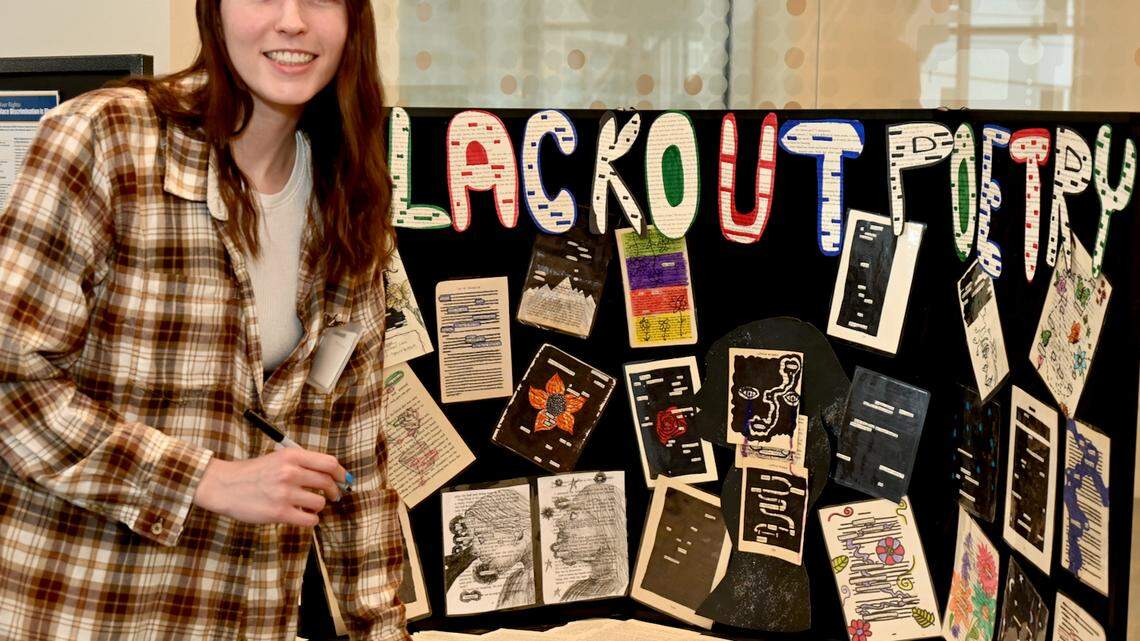 PLYMC Librarian Brianna Sickle in front of the Blackout Poetry display