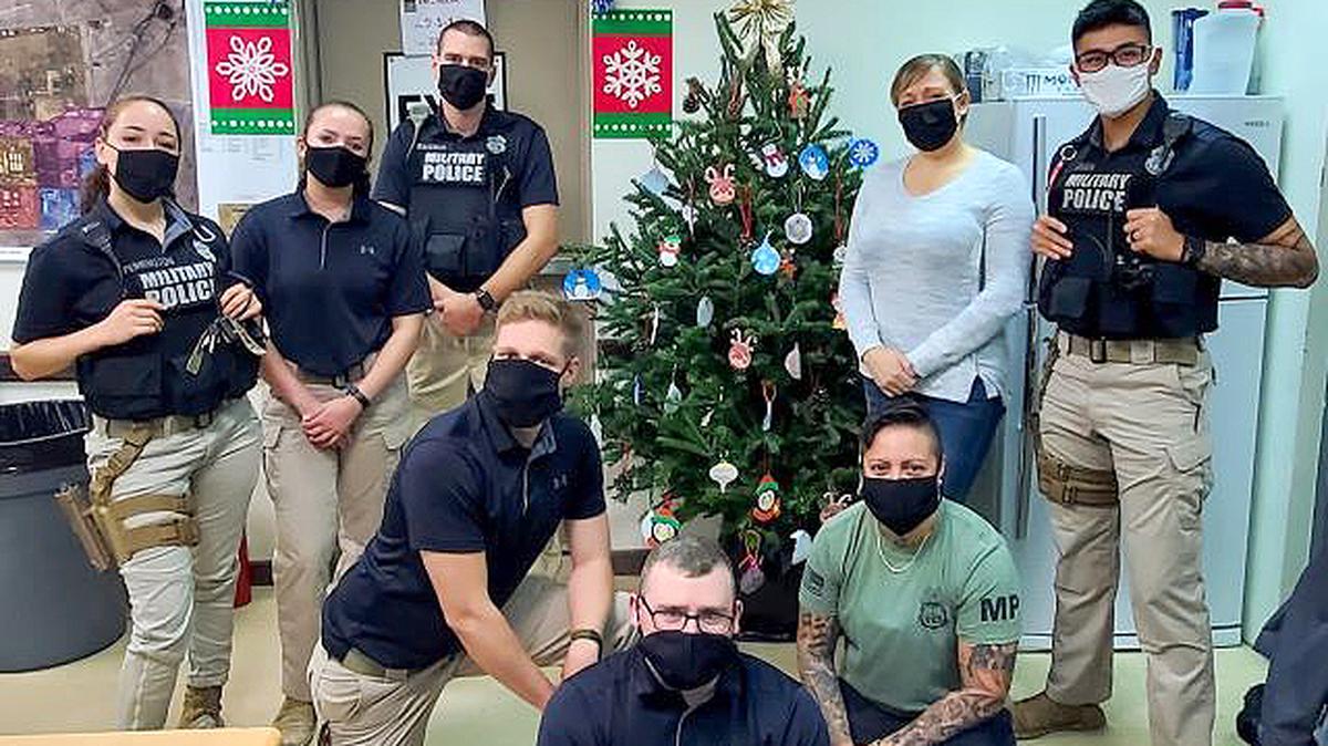U.S. soldiers are seen in front of a decorated Christmas tree. Boardman Center Intermediate School recently received a “thank you” for sending ornaments to soldiers overseas. (Contributed photo)
