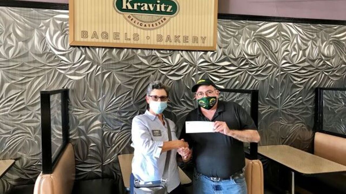 Suzanne Barbati, president and executive director of OH WOW! The Roger & Gloria Jones Children’s Center for Science & Technology, accepts a $500 donation from Jack Kravitz, president of Kravitz Delicatessen. (Contributed photo)