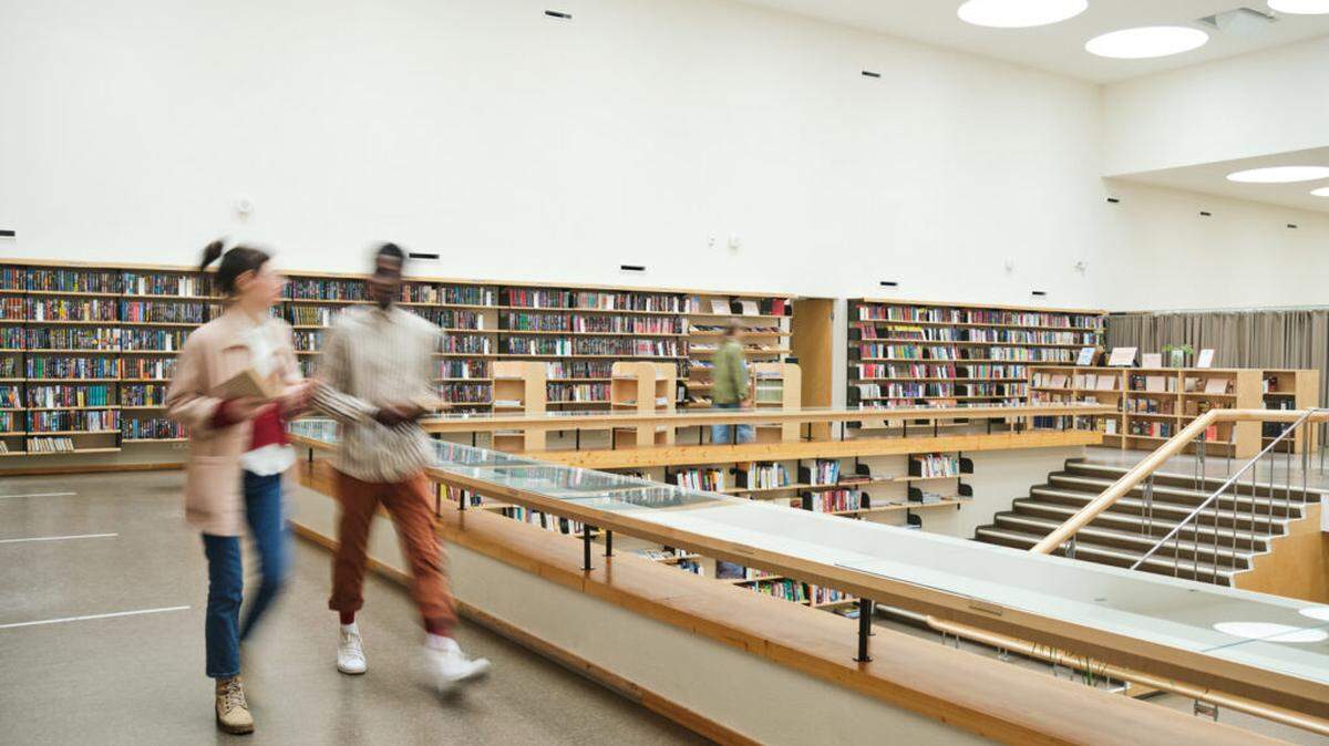 Blurred motion of people walking in library