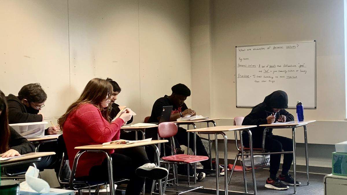 High school students working on embroidery and writing during lunch break at Potential Development in Youngstown.