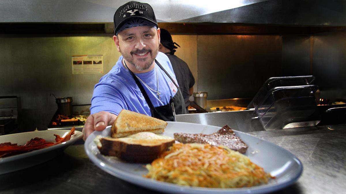 The Landmark Restaurant co-owner Brian Berendt serves up a breakfast order. The restaurant opened its new Liberty location at 1472 Churchill Hubbard Road on Friday, Jan. 28, 2022.