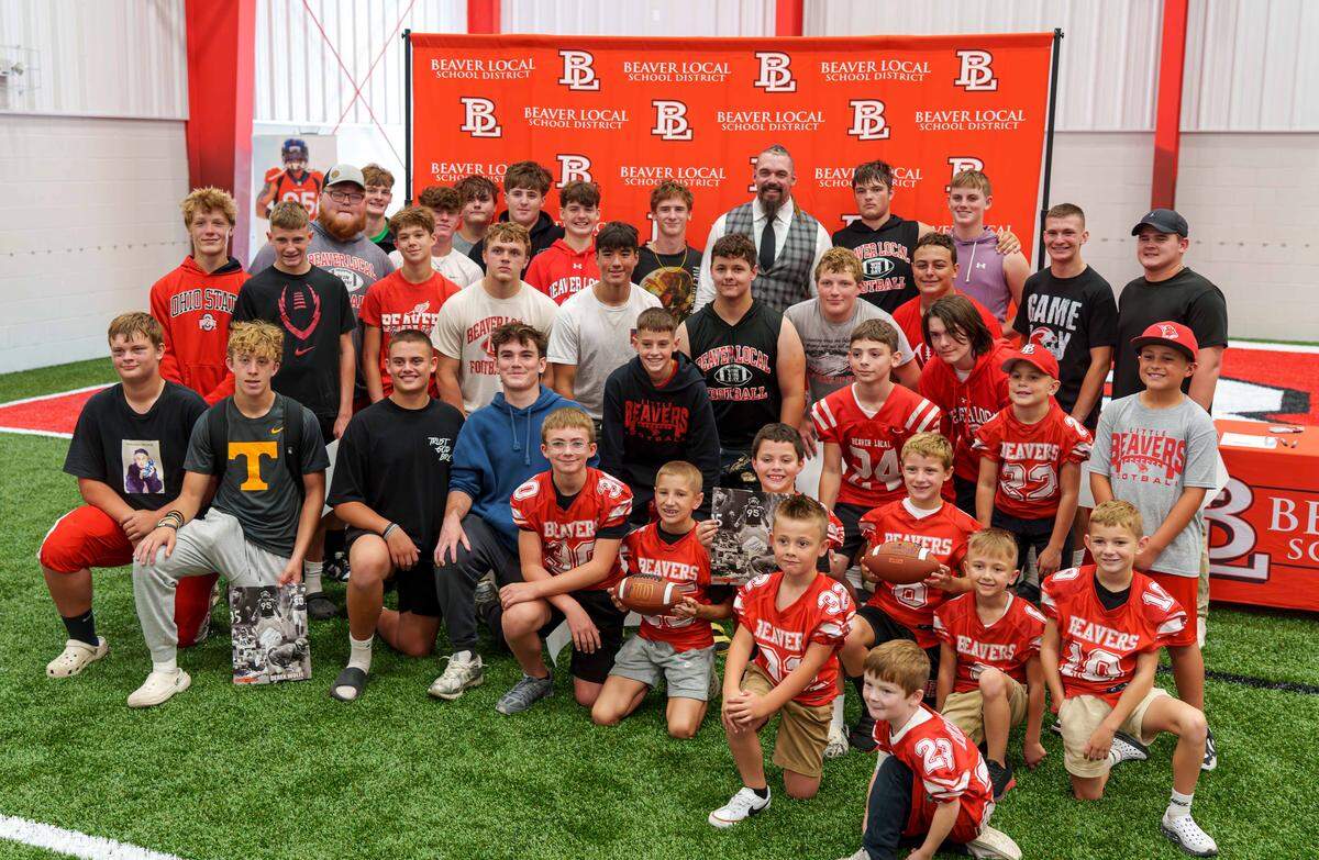 Former NFL player Derek Wolfe smiles for a photo with local youth while celebrating the ribbon cutting of new Derek Wolfe Fieldhouse at Beaver High School. He was also inducted into the Beaver Local Athletics Hall of Fame during the festivities.