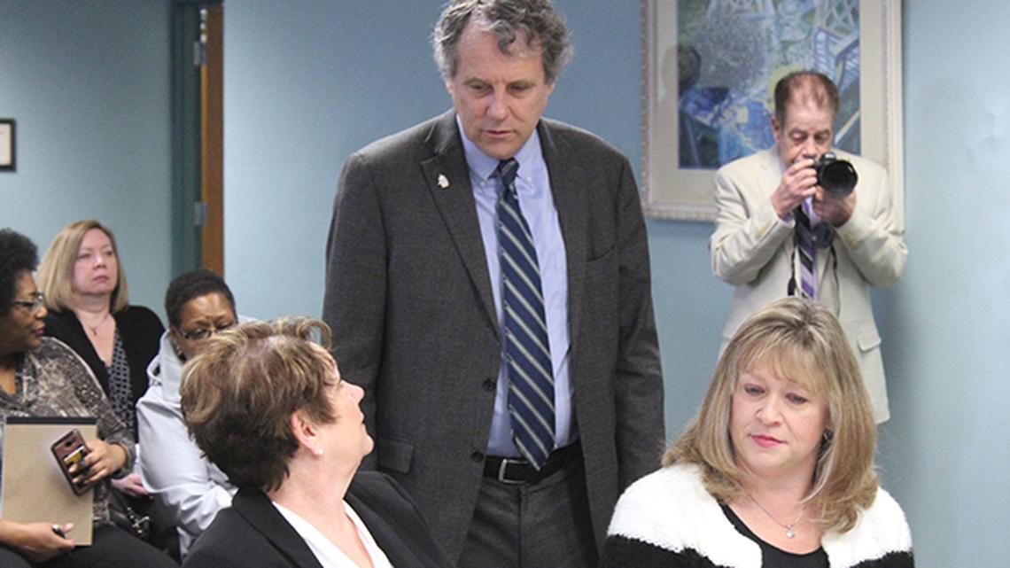 U.S. Sen. Sherrod Brown of Cleveland, D-OH, back, meets with Deb Flora, executive director of the Mahoning County Land Bank, right, and attorney Patricia Dougan of Community Legal Aid during a roundtable discussion on housing Wednesday at the Public Library of Youngstown and Mahoning County's Wick Avenue branch. (Justin Dennis | Mahoning Matters)