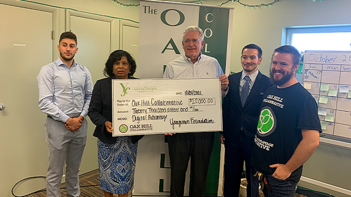 Lynnette Forde, president of The Youngstown Foundation, presents a check to Pat Kerrigan, executive director of the Oak Hill Collaborative. Joining them are, from left, Youngstown Foundation interns Ross Fabrizi and James DiMuccio and Oak Hill Collaborative IT Director Anthony Hake. (Contributed photo)