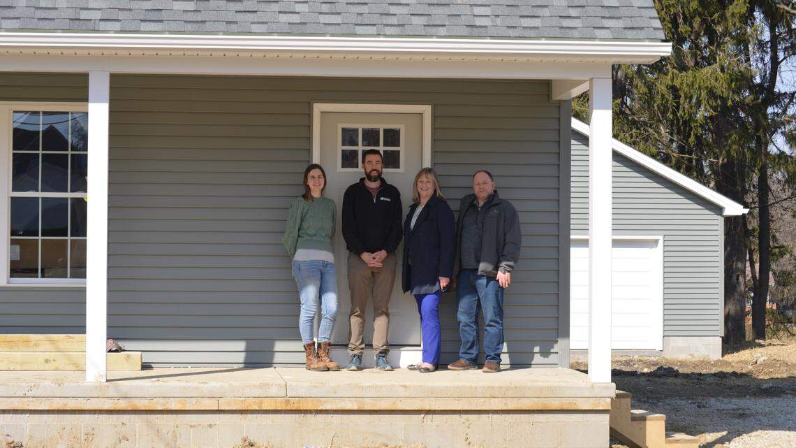 (left to right) Tiffany Sokol and Ian Beniston of the Youngstown Neighborhood Development Corp. stand in front of one of the newly built homes alongside Mahoning County Land Bank’s Debora Flora and Roger Smith.