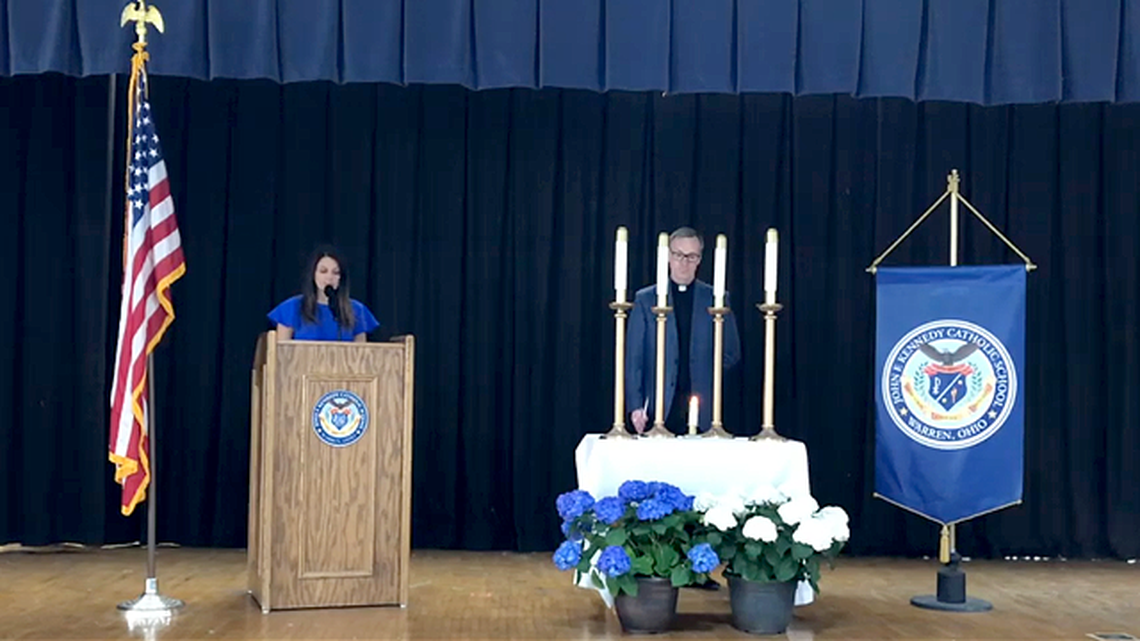 Warren JFK Principal Alyse Consiglio and the Rev.  John Michael Lavelle, director of faith formation, light candles to reflect the pillars of leadership, scholarship, service, and character during the school's online National Honor Society induction ceremony. (Contributed photo)