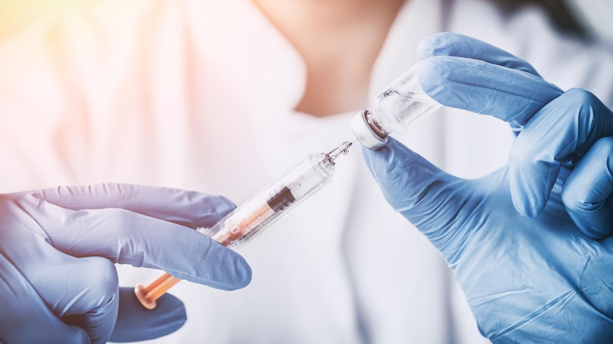 A photo of a doctor preparing a vaccine.