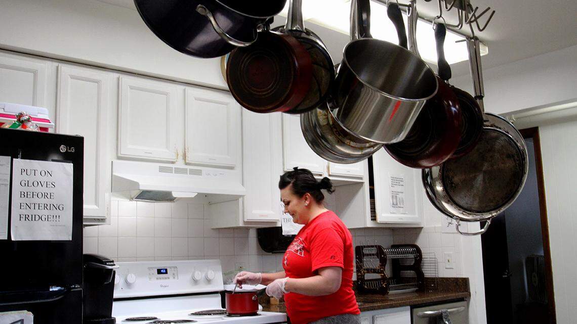 Megan Watt prepares food in the kitchen at Catholic Charities’ Voice of Hope Shelter in Youngstown on April 6, 2022. She’s been a resident of the shelter for about four months, she said.