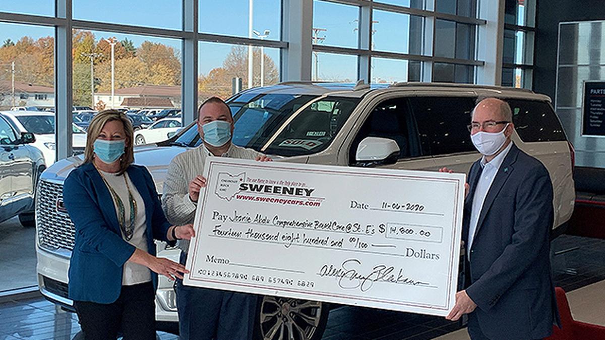 Derek Snyder, executive manager and partner at Sweeney Chevrolet Buick GMC, and Alexa Sweeney Blackann, Sweeney president, present a check to Paul Homick Jr., Mercy Health Foundation — Mahoning Valley president. (Contributed photo)