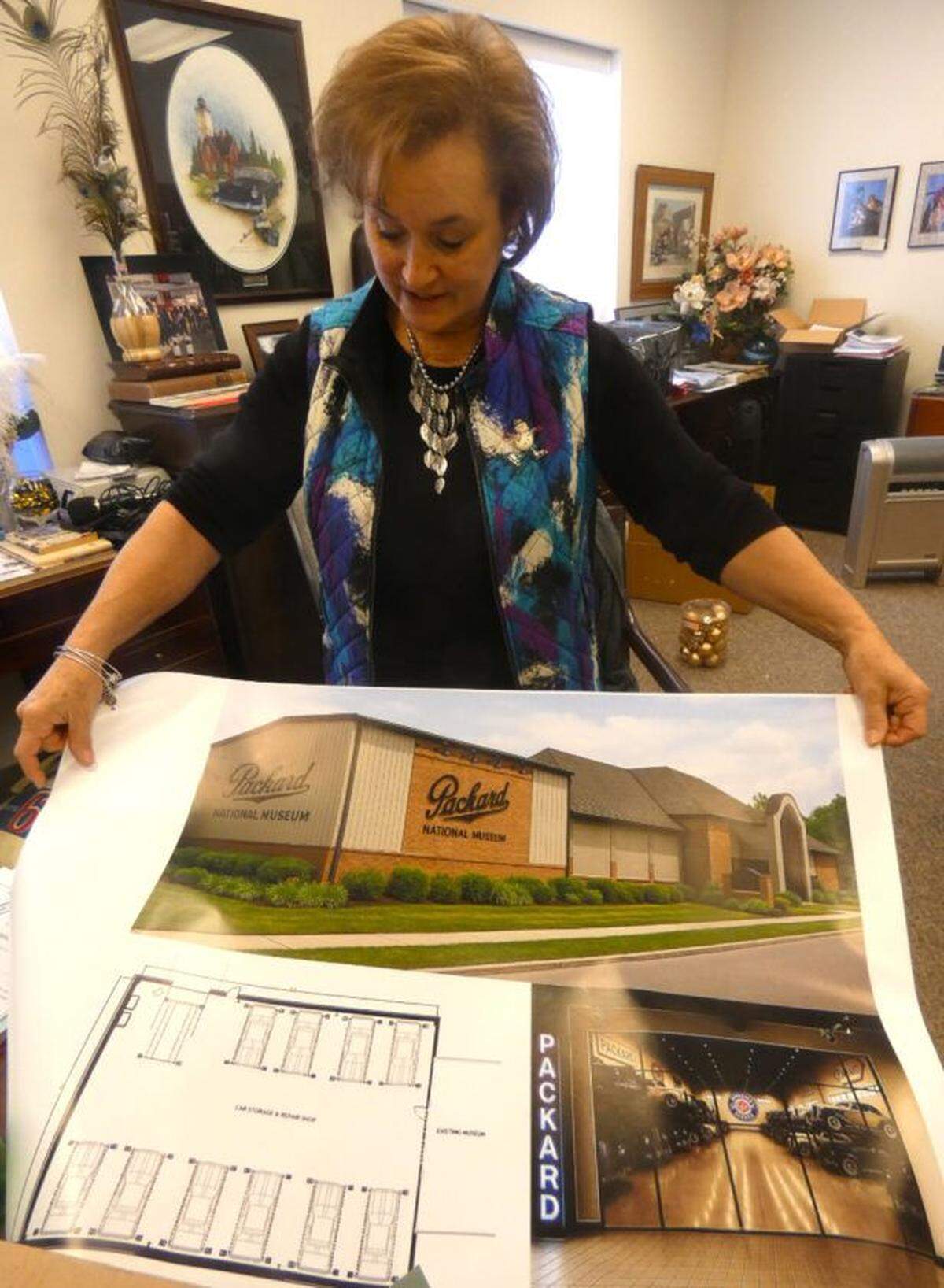 Mary Ann Porinchak, executive director of the National Packard Museum, holds a blueprint of the on-site automobile repair shop that’ll soon be added to the museum in Warren.
