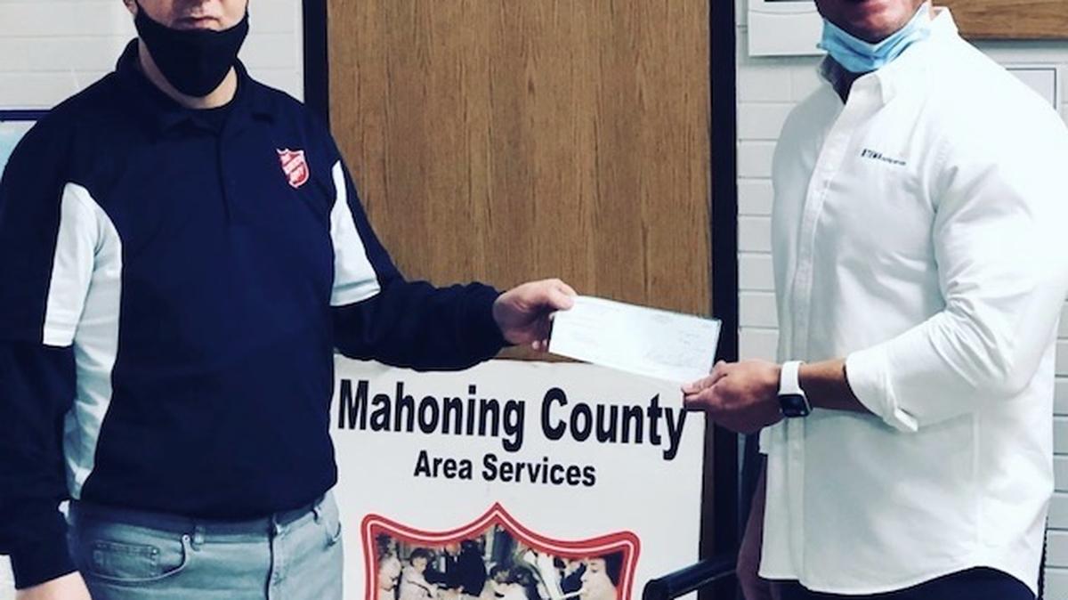 Major Paul Moore of the Salvation Army accepts a check from Justin Froelich, vice president of sales at TEMA Roofing Services. Online Justin wrote, "What a wonderful experience partnering up with Mahoning Matters" to deliver "a fantastic check to the Salvation Army of Youngstown for all their contributions to this wonderful community and its fantastic citizens.” (Photo provided)