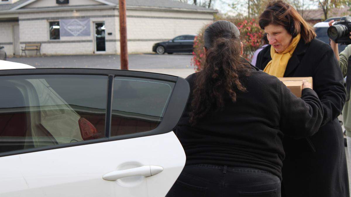Physician at Akron Children’s and daughter of Attorney Rossi Dr. Elana Rossi helps a parent load a food box in their car.