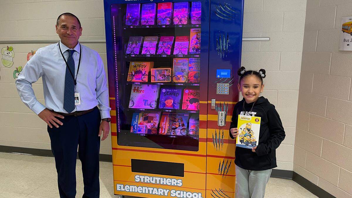 Each week, Struthers Elementary students can turn in their “Wildcat Win” tokens received for demonstrating positive behaviors, in exchange for new books from the building’s book vending machine. Elementary principal Dennis Hynes congratulates recent winner fourth grader Aryanna Gonzalez who got a new Minions book.