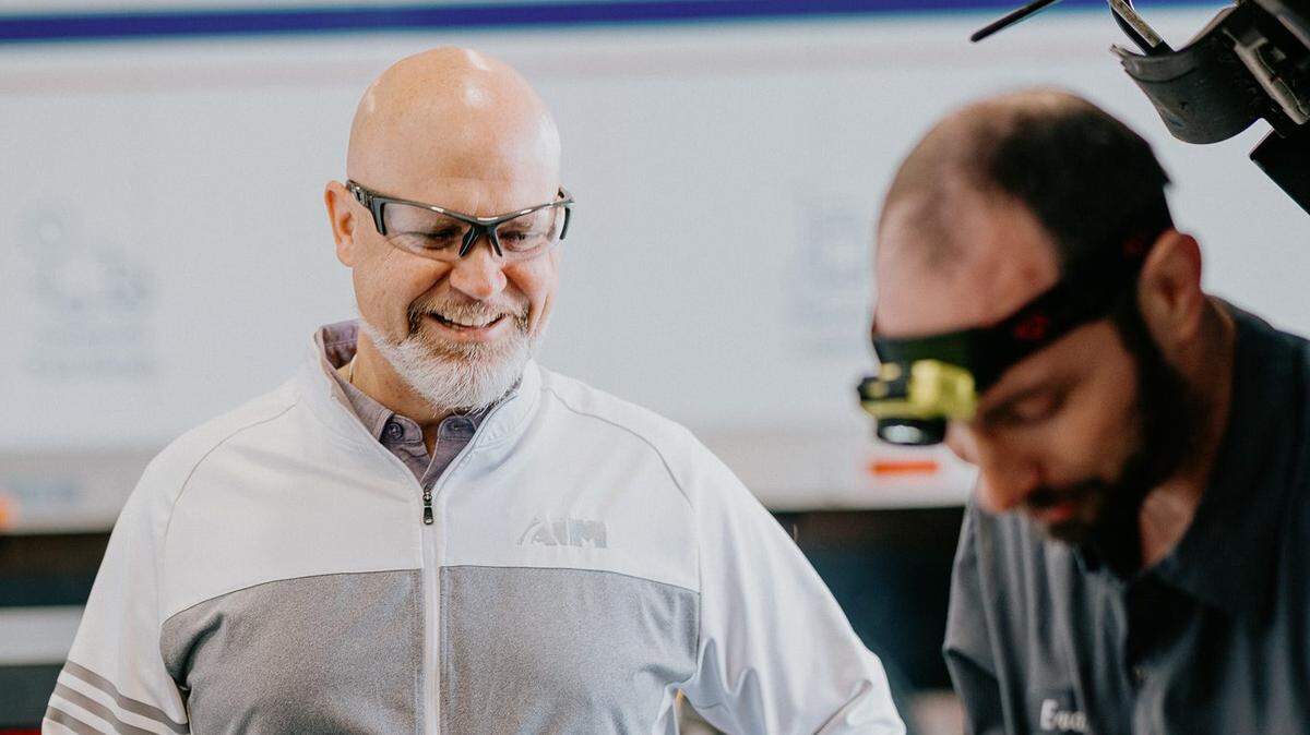Scott Fleming, president of Aim Transportation Services, visits with one of Aim’s diesel technicians.