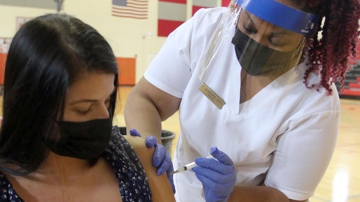 Chaney High School as Youngstown City Schools.. employees got their second of two COVID shots. Inside the Gymnasium.  Choffin School of Practical Nursing students and the Youngstown Health Dept administered the vaccines

Kindergarten Teacher  Savanna (ok) Boals from Kirkmere gets the second shot in her left arm by a left handed Choffin Tasade Queener (ok)