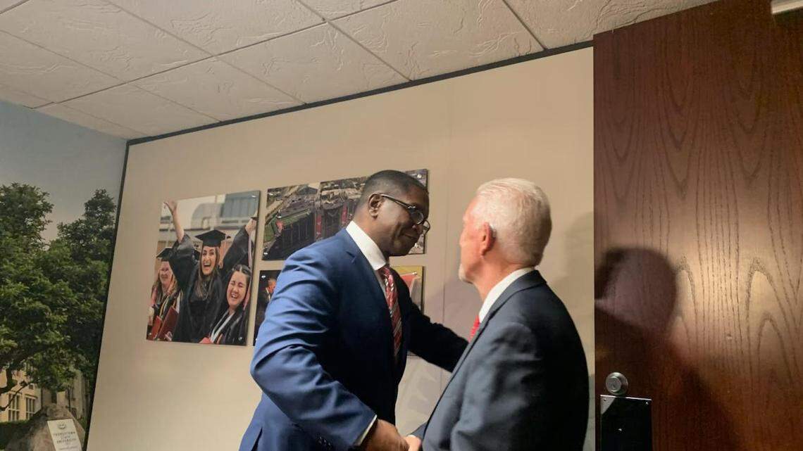 Youngstown State Trustees Chairman Michael A. Peterson greets U.S. Rep. Bill Johnson during a press conference announcing Johnson as their selection for the new president of the school.