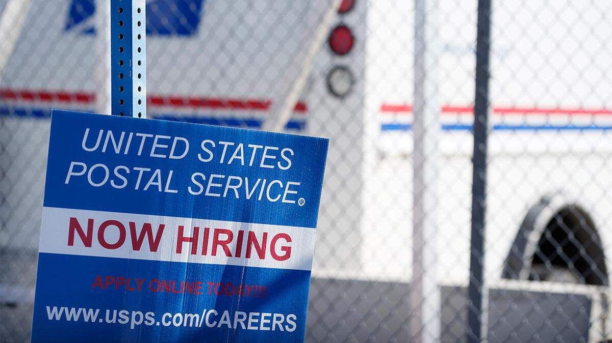 A now hiring sign is seen outside a U.S. Postal Service office in Commerce City, Colorado, on Nov. 7, 2021.