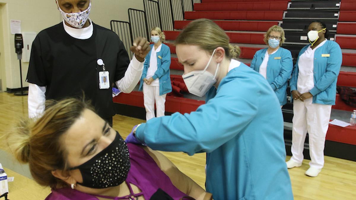 Youngstown City Schools held a clinic at Chaney High School gym. Choffin students in the LPN class got hands on experience as they did vaccinations under their instructor Al Davis.

Al Davis watches as Marily Veryamani (ok) injects the vaccine into 2nd grade teacher from McGuffey School Michelle Sebaugh (purple)