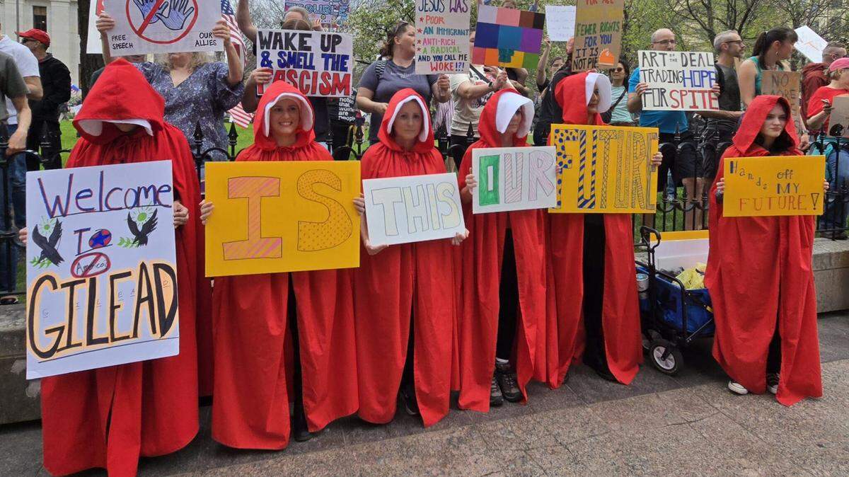 Protesters dressed as characters in “The Handmaid’s Tale,” a dystopian novel about life under a totalitarian regime. They were protesting President Donald Trump at the Ohio Capitol on April 19.