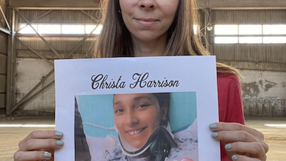Penguin City Brewery co-owner Aspasia Lyras-Bernacki holds a poster promoting a fundraiser for shooting victim Christa Harrison.